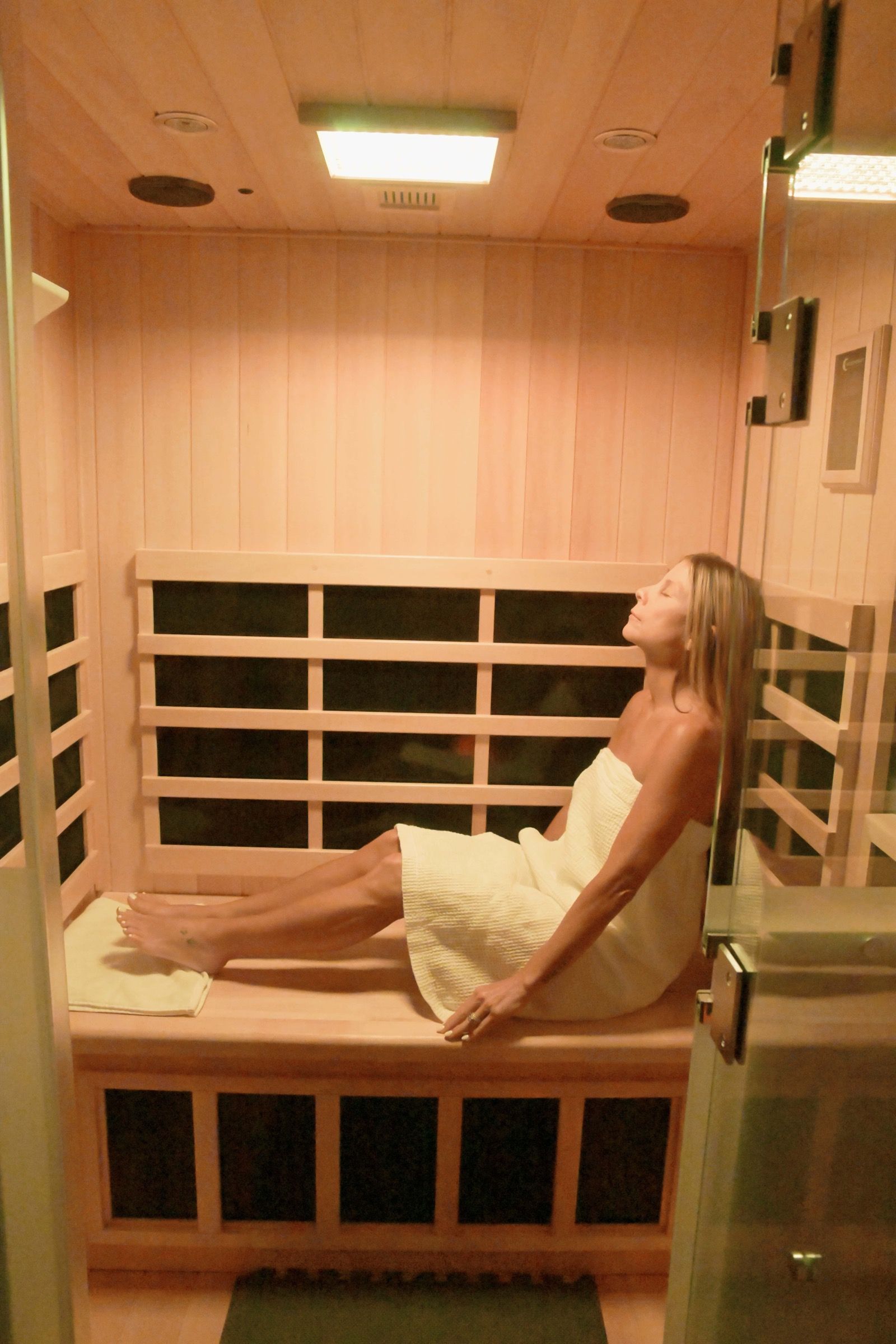 Guest relaxing inside the warm infrared HaloSauna during a Purification Ritual at Stillness & Aesthetics Co. in New Port Richey, FL